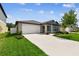 Beautiful home featuring a two-car garage, well-kept lawn, and attractive landscaping at 13235 Palmerston Rd, Riverview, FL 33579