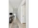 Bright and airy hallway with neutral tile flooring and a console table with decor, leading to the living areas at 13235 Palmerston Rd, Riverview, FL 33579
