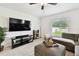 Cozy living room with large TV, comfortable seating, and natural light from the window at 13235 Palmerston Rd, Riverview, FL 33579