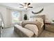Bright main bedroom featuring neutral tones, a ceiling fan, and a large window letting in plenty of natural light at 13235 Palmerston Rd, Riverview, FL 33579