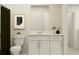 Well-lit bathroom featuring a white vanity, decorative plants, and a framed print against a neutral wall at 13539 White Gold Run, Parrish, FL 34219