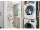 Bathroom with stackable washer-dryer, toilet, sink, and shower with floral shower curtain at 1371 Mission Hills Blvd, Clearwater, FL 33759