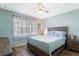 Comfortable bedroom with a queen bed, ceiling fan, wood floors, and natural light at 1371 Mission Hills Blvd, Clearwater, FL 33759