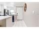 Bright entryway with white tile flooring, complemented by kitchen featuring stainless steel appliances in background at 1371 Mission Hills Blvd, Clearwater, FL 33759