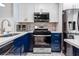 Charming kitchen boasting white cabinets, stainless steel appliances, and stylish blue lower cabinets at 1371 Mission Hills Blvd, Clearwater, FL 33759