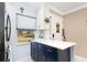 Bright kitchen featuring white countertops, blue cabinets and view of neighborhood through window at 1371 Mission Hills Blvd, Clearwater, FL 33759