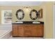 A vanity with a double sink and dark granite countertop and decoratively framed mirrors at 15123 Bald Eagle St, Tampa, FL 33625