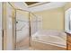The bathroom includes a bathtub, walk-in shower with grab bars, and cream-colored tile at 15123 Bald Eagle St, Tampa, FL 33625