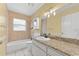 Bright bathroom featuring a shower-tub combo and a granite countertop vanity with a white sink at 15123 Bald Eagle St, Tampa, FL 33625