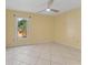 Cozy bedroom with tile flooring, a window view, and soft yellow walls at 15123 Bald Eagle St, Tampa, FL 33625
