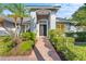 Home's entryway featuring a brick walkway, manicured bushes, and an elegant front door with sidelights at 15123 Bald Eagle St, Tampa, FL 33625
