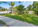 Well-maintained front yard showcasing lush green grass, a mature mango tree, and decorative landscaping at 15123 Bald Eagle St, Tampa, FL 33625