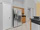 Kitchen featuring stainless steel refrigerator, white door, granite countertops, and tile floors at 15123 Bald Eagle St, Tampa, FL 33625