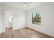 Empty bedroom showcasing natural light, hardwood floors, and ensuite bathroom at 15218 Appleton Blvd, Port Charlotte, FL 33981