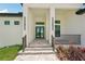 Welcoming entrance with tiled steps, black metal railings, and modern lighting fixtures at 15218 Appleton Blvd, Port Charlotte, FL 33981