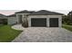 Beautifully landscaped home featuring a two-car garage and elegant stone driveway at 15218 Appleton Blvd, Port Charlotte, FL 33981