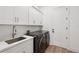Bright laundry room features modern washer and dryer, sink with quartz countertop, and storage at 15218 Appleton Blvd, Port Charlotte, FL 33981