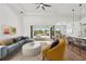 Staged living room with a ceiling fan and access to the kitchen and outdoor lanai at 15218 Appleton Blvd, Port Charlotte, FL 33981