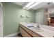 Well-lit bathroom featuring a large mirror, fresh paint, and storage vanity at 1709 Castle Rock Rd, Tampa, FL 33612