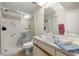 Well-lit bathroom with a glass-enclosed shower, a vanity with sink, and tiled walls throughout at 1709 Castle Rock Rd, Tampa, FL 33612