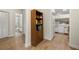 Hallway leading to the bathroom and kitchen featuring wood-look flooring and neutral paint throughout the home at 1709 Castle Rock Rd, Tampa, FL 33612