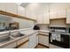 Efficient kitchen layout featuring white cabinets, laminate countertops, and essential appliances at 1709 Castle Rock Rd, Tampa, FL 33612