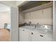 Convenient laundry area with modern washer and dryer, shelving, and bright lighting in the home at 1709 Castle Rock Rd, Tampa, FL 33612