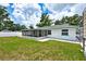 A full view of the backyard, showing the screened-in porch and the grassy yard at 17824 Morninghigh Dr, Lutz, FL 33549