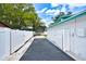 Driveway leading to the back of the house, enclosed by a white privacy fence at 17824 Morninghigh Dr, Lutz, FL 33549