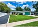 Charming single-story home with a green lawn, a well-kept garden, and a vibrant turquoise garage door at 17824 Morninghigh Dr, Lutz, FL 33549