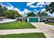 Charming single-story home with a well-kept garden and a vibrant turquoise garage door at 17824 Morninghigh Dr, Lutz, FL 33549