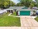 Aerial front elevation showing a well-manicured lawn and vibrant turquoise garage door at 17824 Morninghigh Dr, Lutz, FL 33549