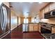 An eat-in kitchen features stainless steel appliances, dark wood flooring, and wood cabinetry at 17824 Morninghigh Dr, Lutz, FL 33549