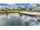 Community swimming pool with white deck overlooking pond with water fountain at 200 Country Club Dr # 202, Largo, FL 33771