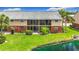 Exterior view of apartments with a beautiful landscape and a pond at 200 Country Club Dr # 202, Largo, FL 33771