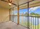 A screened patio overlooking a serene lake with lush landscaping and a ceiling fan for added comfort at 200 Country Club Dr # 202, Largo, FL 33771