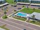 Overhead view of a community pool, clubhouse, parking, and surrounding residential area with palm trees at 214 Caryl Way, Oldsmar, FL 34677