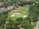 Expansive aerial view shows a lush golf course surrounded by homes and mature trees at 214 Caryl Way, Oldsmar, FL 34677
