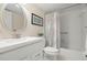 Bright bathroom featuring a white vanity, oval mirror, and a shower-tub combo with decorative curtain at 214 Caryl Way, Oldsmar, FL 34677