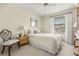 Bright bedroom featuring a ceiling fan, large window and chair with a decorative pillow at 214 Caryl Way, Oldsmar, FL 34677