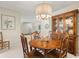 A dining area features a round table, chandelier, cabinet and a peek into other rooms at 214 Caryl Way, Oldsmar, FL 34677
