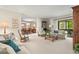 Spacious living room with neutral decor, glass table, and view into the dining area and screened patio at 214 Caryl Way, Oldsmar, FL 34677
