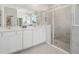 Bright bathroom featuring a double sink vanity, a glass enclosed shower, and neutral tile at 2328 Stratten Dr, Zephyrhills, FL 33541