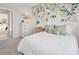Serene bedroom with botanical wallpaper, white bedding, and natural light at 2328 Stratten Dr, Zephyrhills, FL 33541