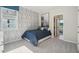 Cozy bedroom with blue bedding, wood-patterned wall, and ample natural light at 2328 Stratten Dr, Zephyrhills, FL 33541