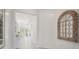 Bright hallway with white walls, tile flooring, and decorative mirror accent at 2328 Stratten Dr, Zephyrhills, FL 33541