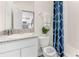 Bathroom featuring granite countertop vanity, white cabinets, toilet, and shower with stylish blue patterned curtain at 2328 Stratten Dr, Zephyrhills, FL 33541