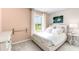 Cozy bedroom featuring soft peach walls, natural light, and a comfortable bed with crisp white linens at 2328 Stratten Dr, Zephyrhills, FL 33541