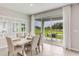 Dining area with modern white table, neutral chairs, and sliding glass doors that open to the outdoors at 2328 Stratten Dr, Zephyrhills, FL 33541