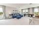 Bright living room with blue sofa, stylish decor, and lots of natural light streaming through large windows at 2328 Stratten Dr, Zephyrhills, FL 33541